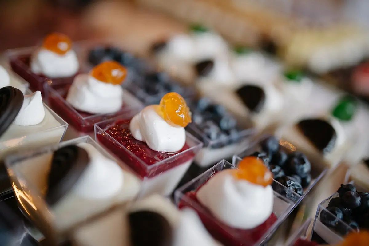 Cupcakes on display with whipped cream and orange topping in focus amongst other cupcakes (49442317043) — illustrative photo