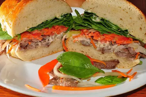 Steak banh mi with spicy mayonnaise on fresh bread — illustrative photo